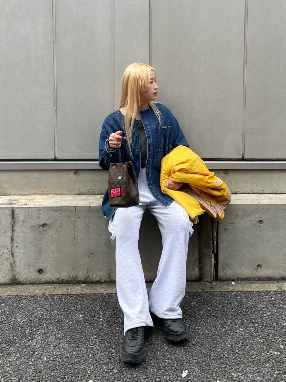 ブラック系のスニーカー、グレー系のパンツを着用したレディースの春コーディネートの3枚目の写真