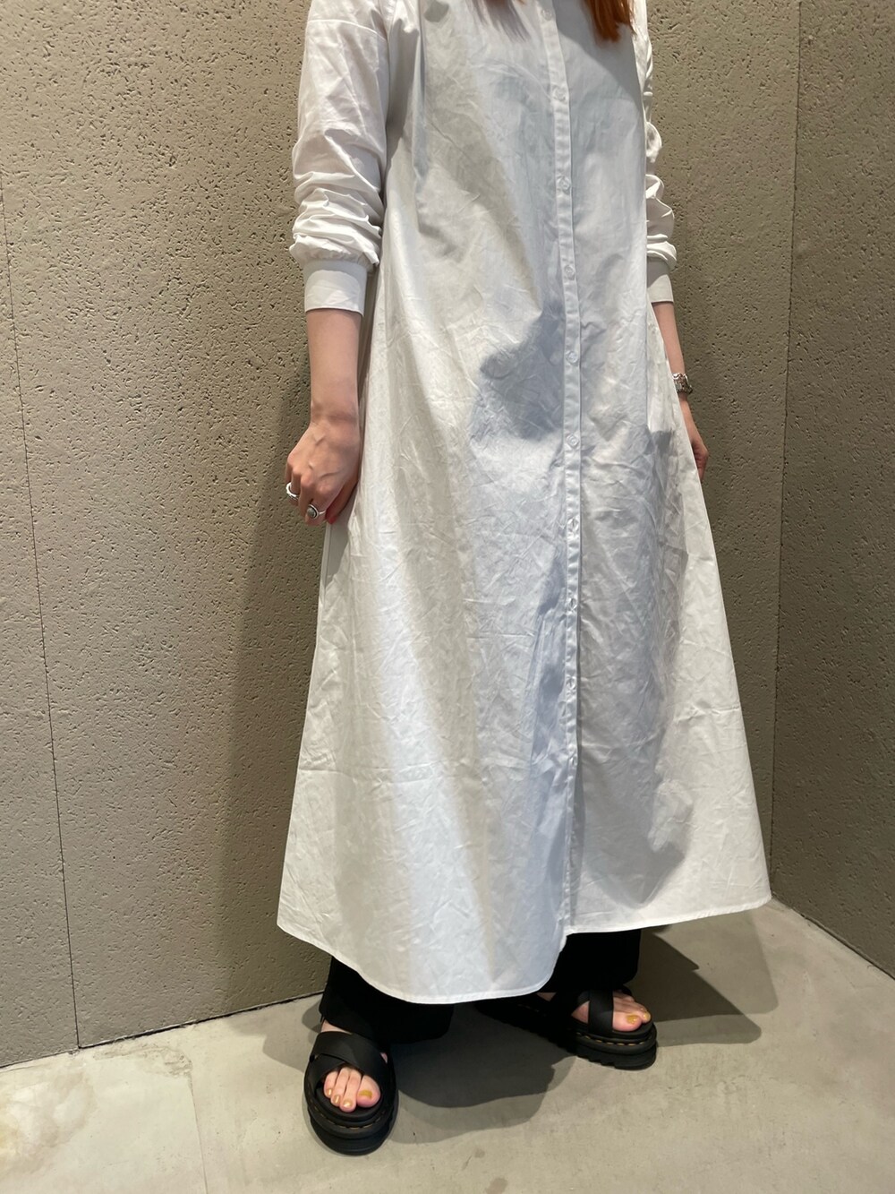 ホワイト系のワンピース、ブラック系のかごバッグ、ブラック系のサンダルを着用したレディースの夏コーディネートの3枚目の写真