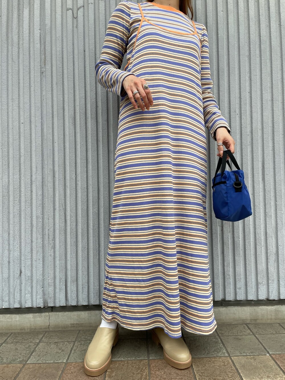 オレンジ系のワンピース、ブルー系のトートバッグを着用したレディースの秋コーディネートの5枚目の写真