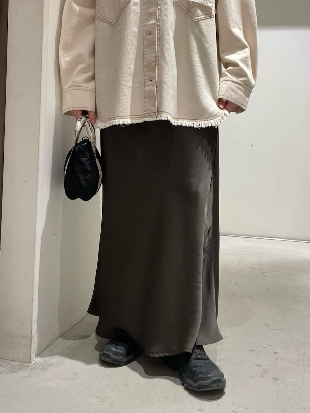 ホワイト系のデニムジャケット、グレー系のスカートを着用したレディースの春コーディネートの6枚目の写真