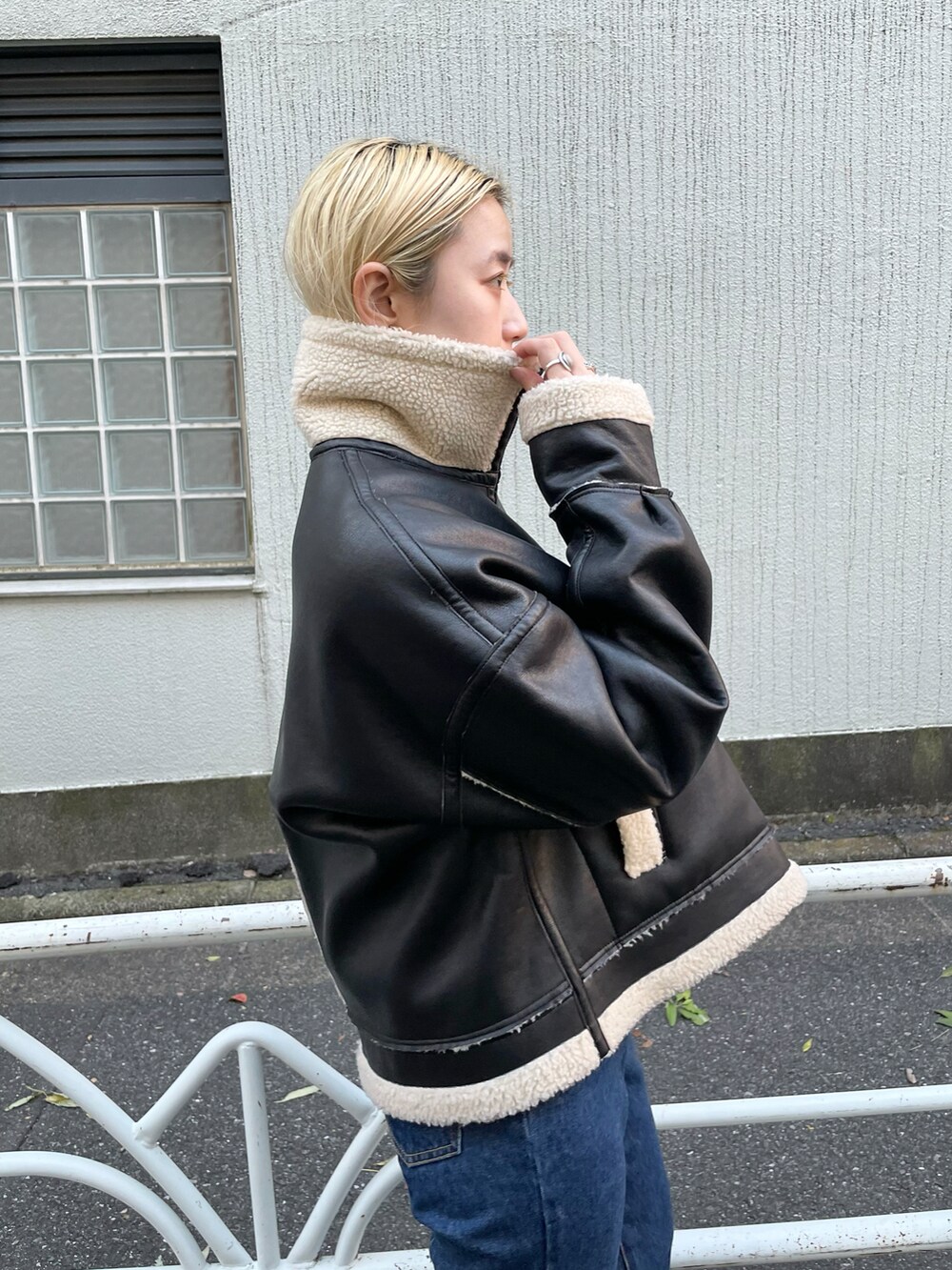 ホワイト系のTシャツ/カットソー、ブラック系のブルゾン、ブルー系のデニムパンツを着用したレディースの秋コーディネートの4枚目の写真