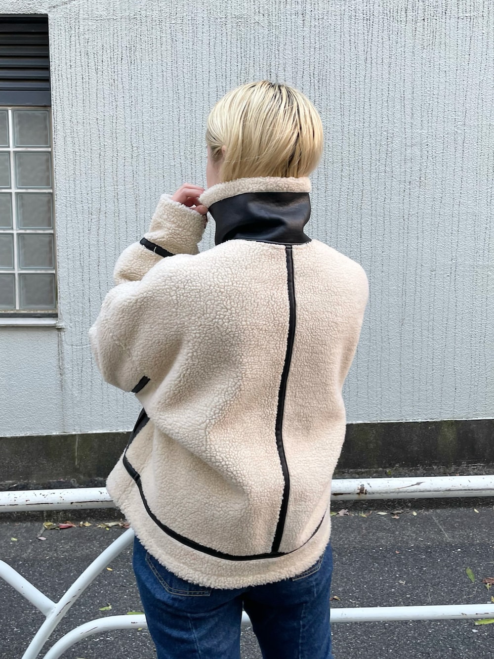 ホワイト系のTシャツ/カットソー、ブラック系のブルゾン、ブルー系のデニムパンツを着用したレディースの秋コーディネートの3枚目の写真