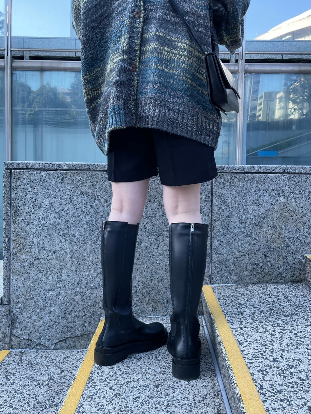 グレー系のカーディガン/ボレロ、ブラック系のその他パンツ、ブラック系のブーツを着用したレディースの冬コーディネートの8枚目の写真