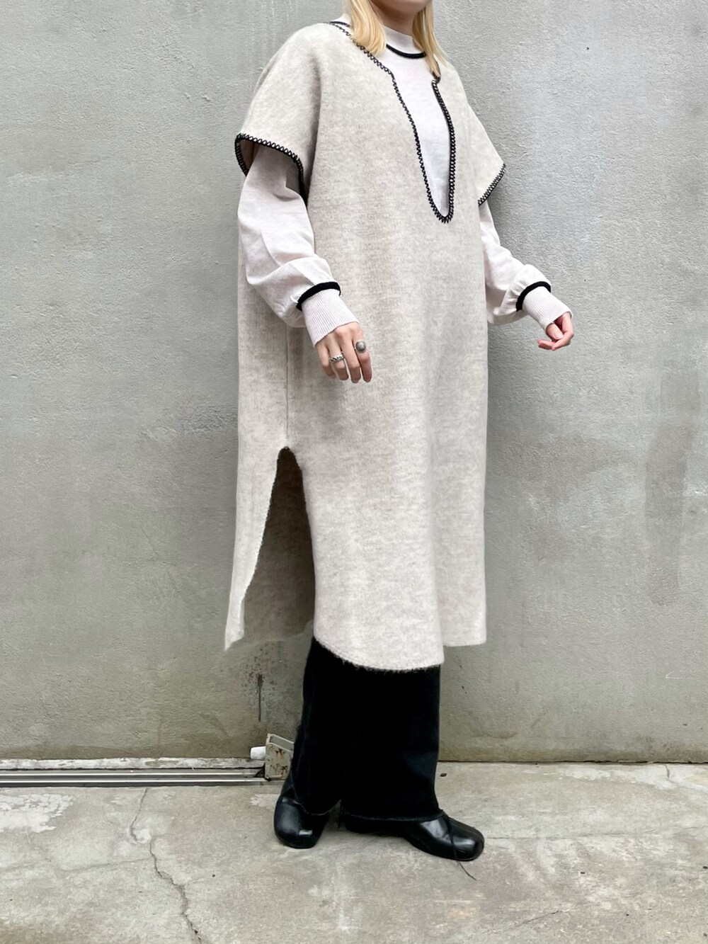 ホワイト系のニット/セーター、ブラック系のデニムパンツ、ブラック系のブーツを着用したレディースの秋コーディネートの2枚目の写真