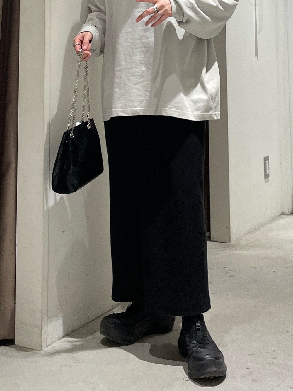 グレー系のTシャツ/カットソー、ブラック系のスカート、ブラック系のショルダーバッグを着用したレディースの春コーディネートの5枚目の写真