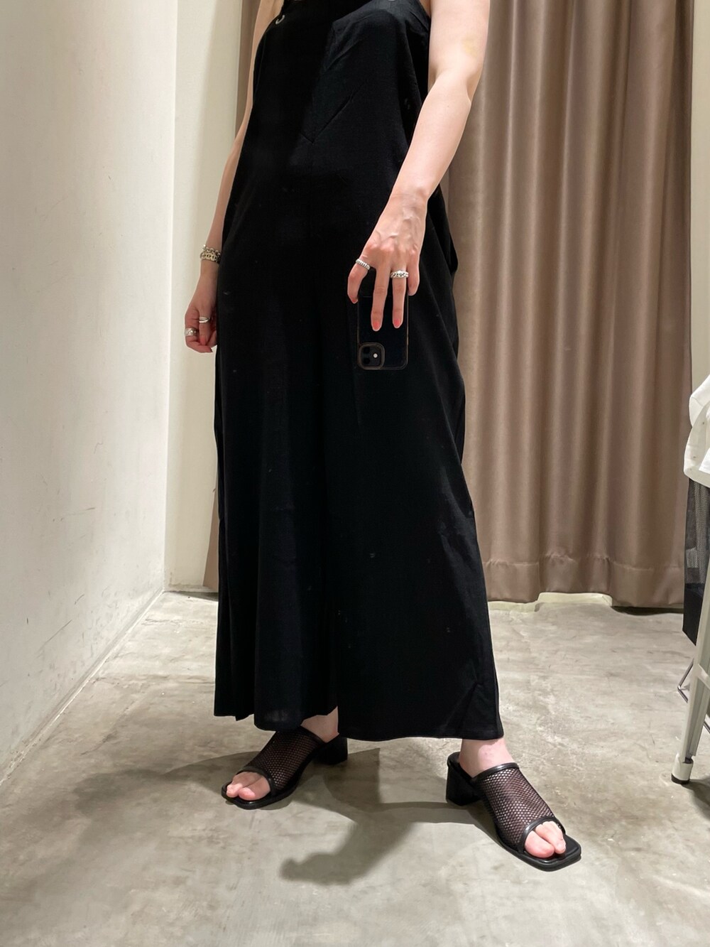 ホワイト系のシャツ/ブラウス、グレー系のサロペット/オーバーオール、ブラック系のサンダルを着用したレディースの春コーディネートの6枚目の写真
