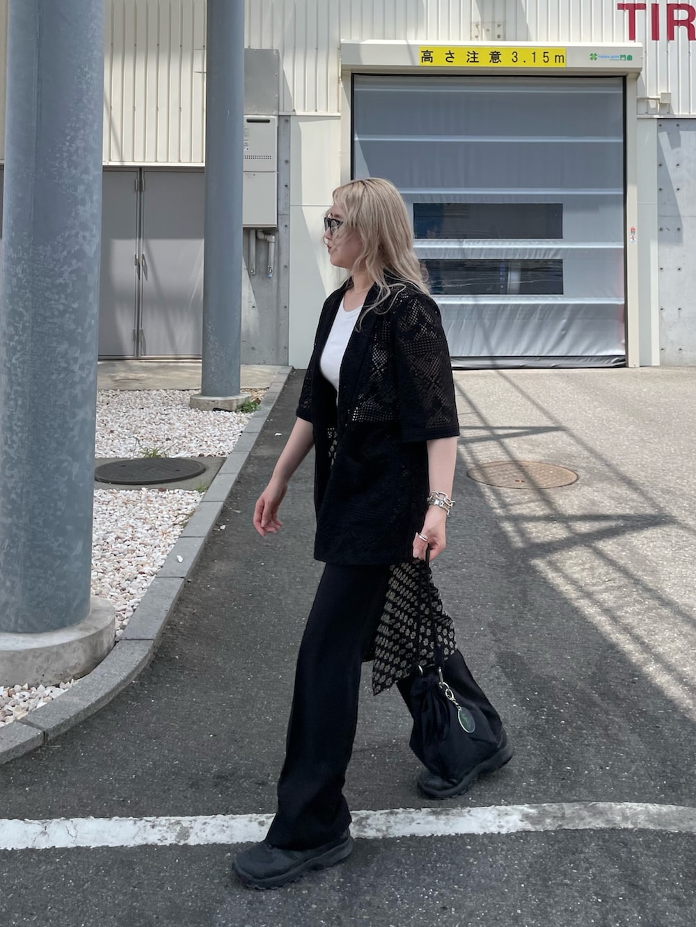 ブラック系のテーラードジャケット、ブラック系のスカート、ブラック系のショルダーバッグを着用したレディースの夏コーディネートの7枚目の写真