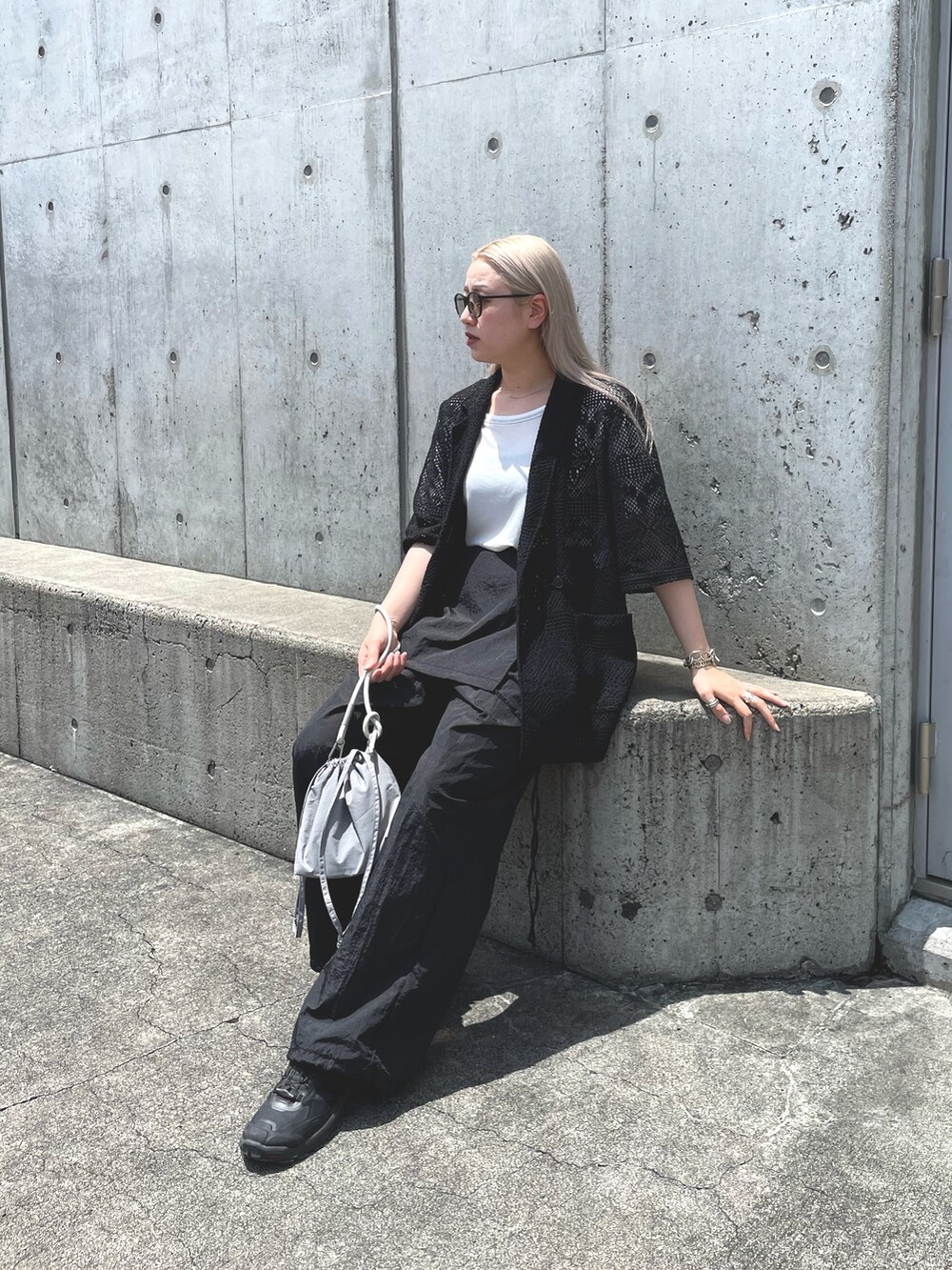ブラック系のテーラードジャケット、グレー系のバッグ、ブラック系のサロペット/オーバーオールを着用したレディースの夏コーディネートの2枚目の写真