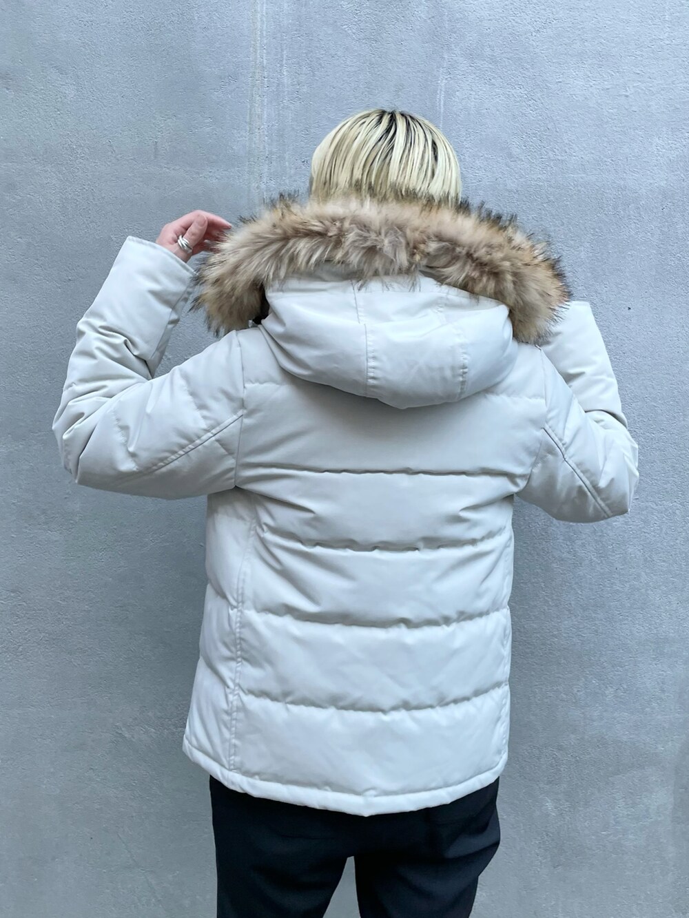 グレー系のダウンジャケット/コート、ブラック系のスラックス、ブラック系のブーツを着用したレディースの秋コーディネートの3枚目の写真