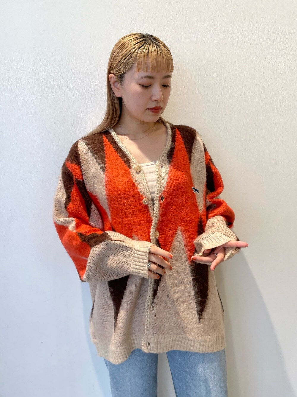 ホワイト系のカーディガン/ボレロ、ブルー系のデニムパンツを着用したレディースの秋コーディネートの3枚目の写真