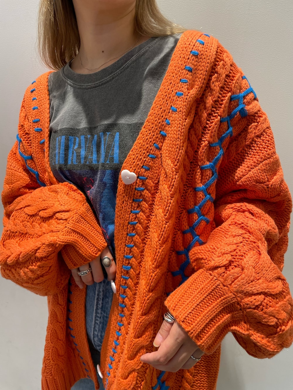 オレンジ系のカーディガン/ボレロ、ブルー系のデニムパンツ、ベージュ系のトートバッグを着用したレディースの秋コーディネートの4枚目の写真