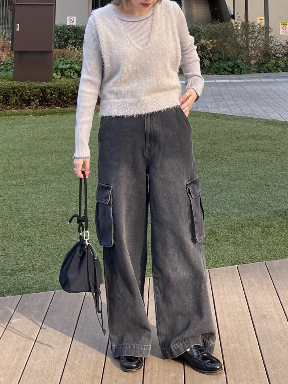 グレー系のベスト、グレー系のニット/セーター、ブラック系のバッグを着用したレディースの冬コーディネートの3枚目の写真