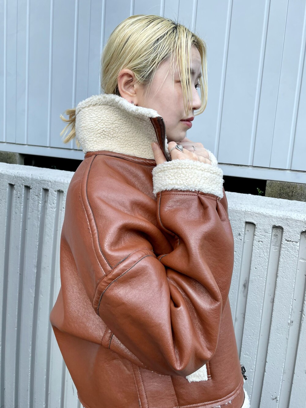 ブラウン系のブルゾン、ブラック系のスカート、ブラック系のブーツを着用したレディースの秋コーディネートの5枚目の写真