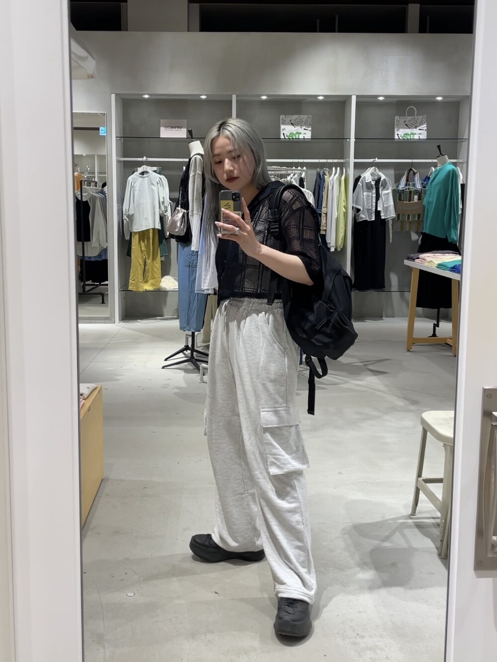 ブラック系のシャツ/ブラウス、グレー系のパンツを着用したレディースの夏コーディネートの2枚目の写真