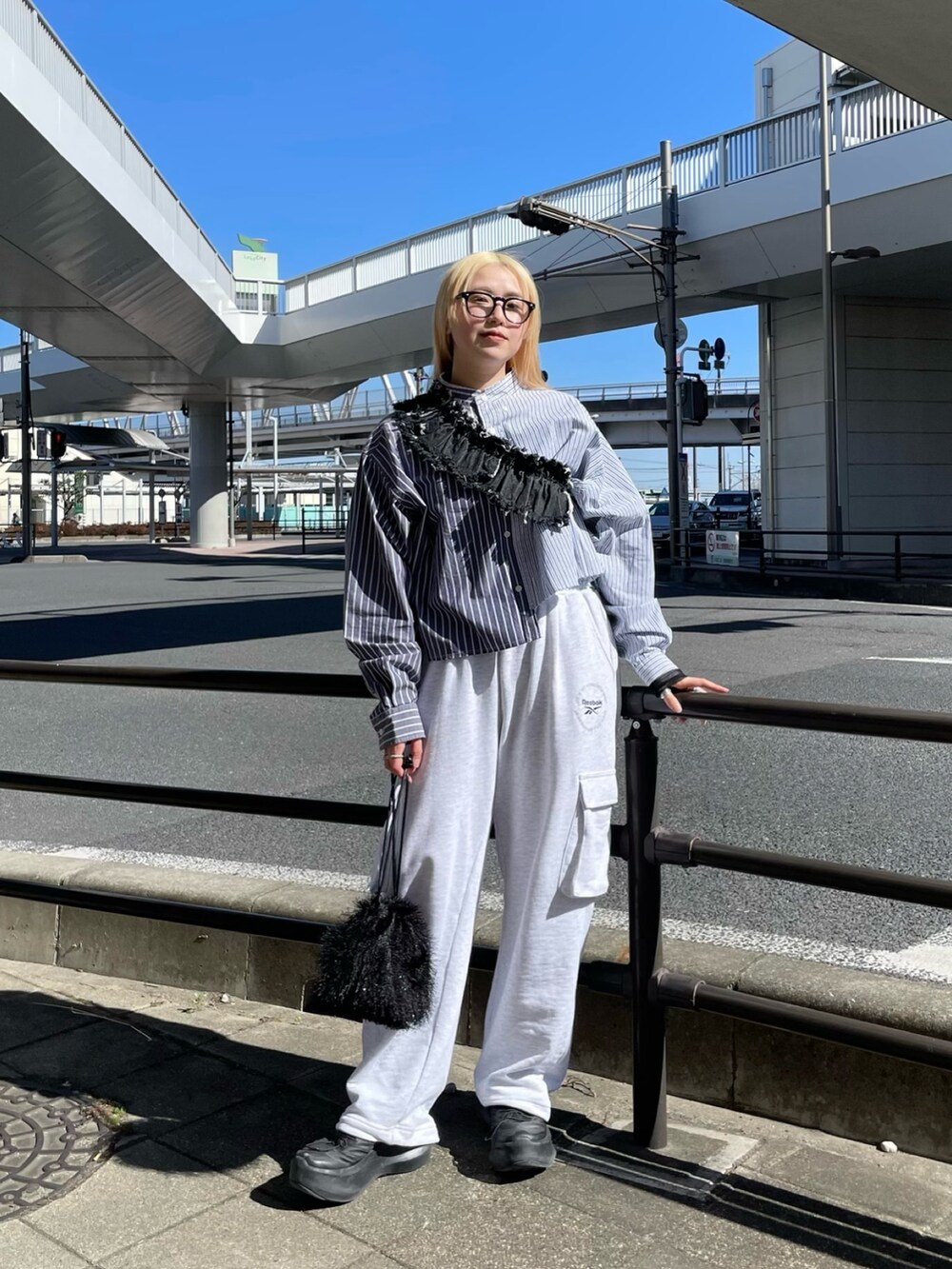 ブルー系のシャツ/ブラウス、ブラック系のデニムスカート、グレー系のパンツを着用したレディースの春コーディネートの7枚目の写真