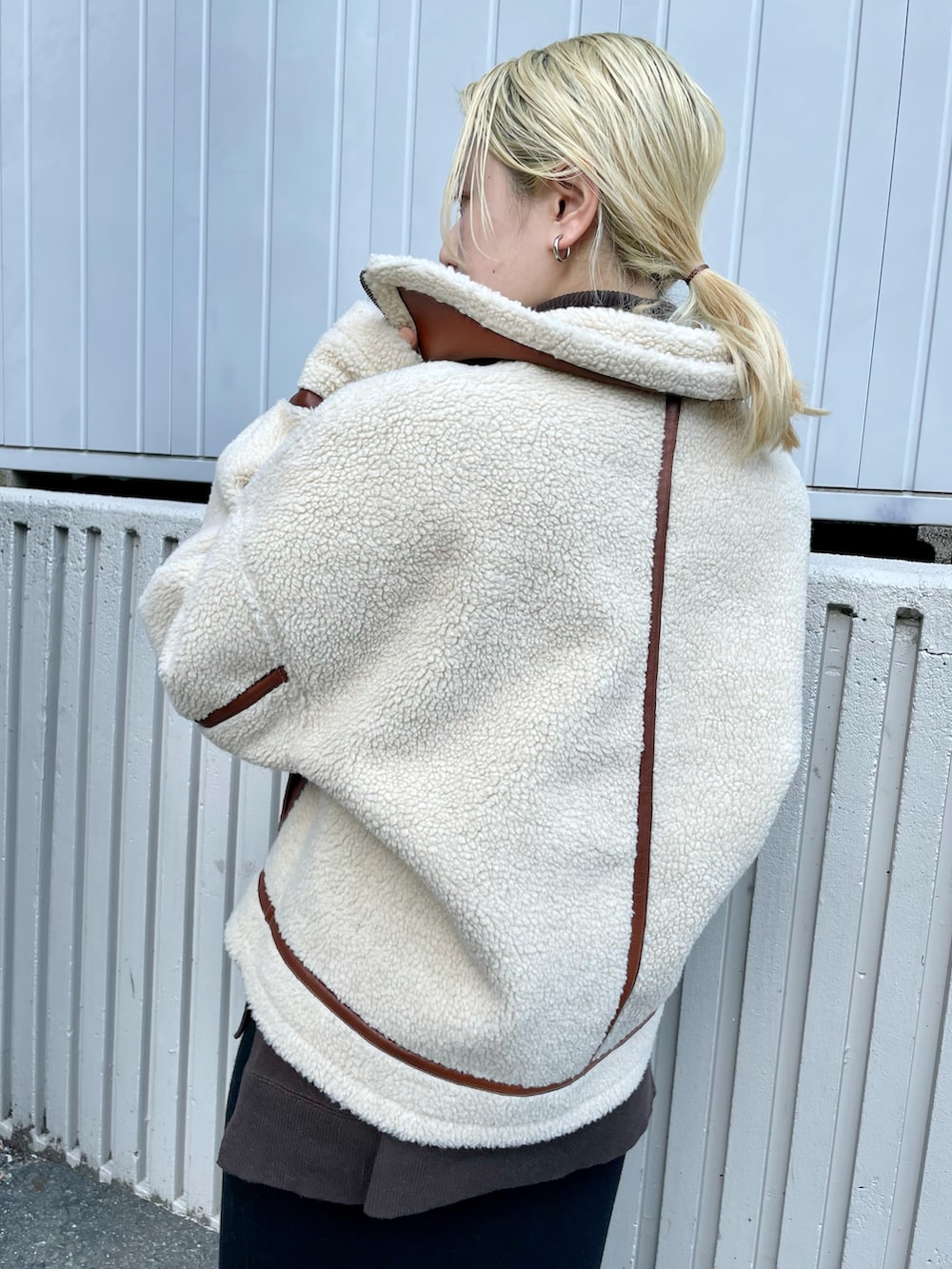 ブラウン系のブルゾン、ブラック系のスカート、ブラック系のブーツを着用したレディースの秋コーディネートの3枚目の写真