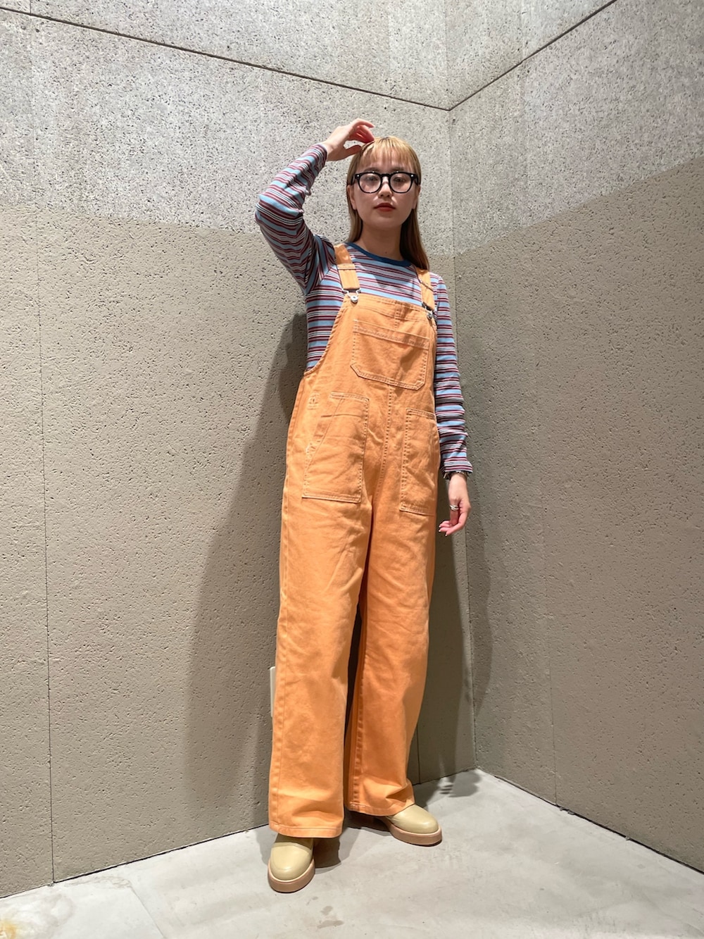 オレンジ系のデニムジャケット、オレンジ系のサロペット/オーバーオール、ブルー系のワンピースを着用したレディースの秋コーディネートの4枚目の写真