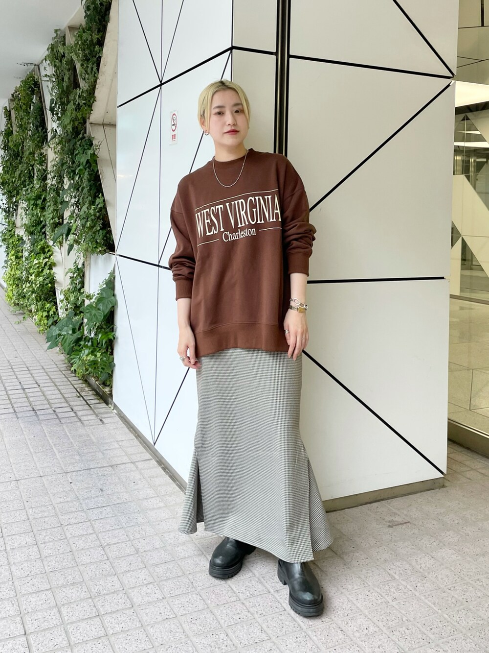 ブラウン系のスウェット、ブラック系のスカートを着用したレディースの秋コーディネートの2枚目の写真