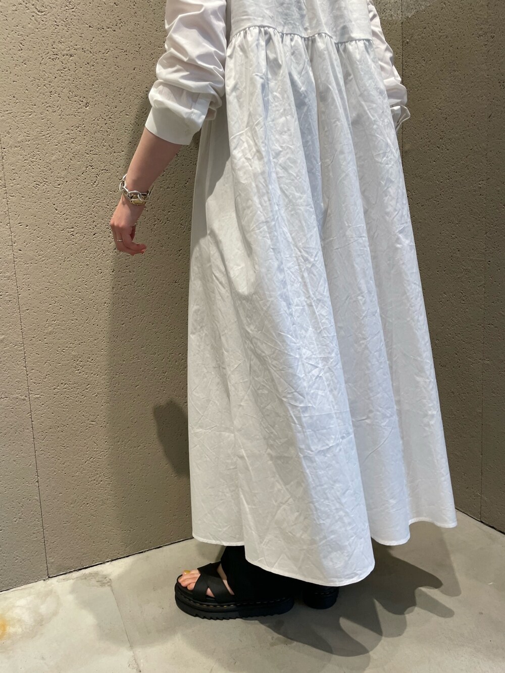 ホワイト系のワンピース、ブラック系のかごバッグ、ブラック系のサンダルを着用したレディースの夏コーディネートの4枚目の写真