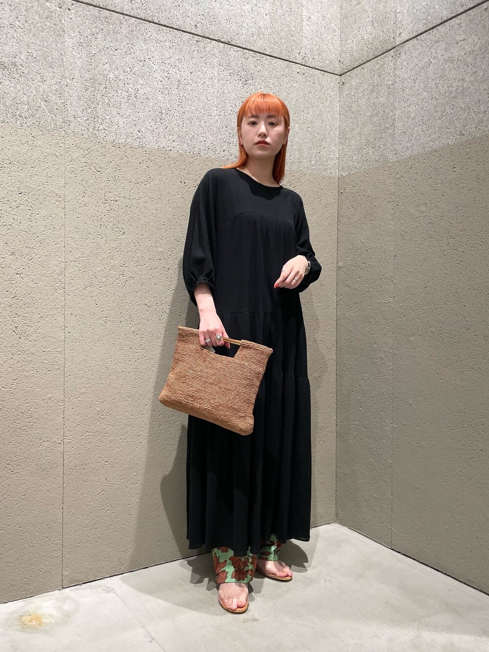 ブラック系のワンピース、ブラウン系のかごバッグ、グリーン系のその他パンツを着用したレディースの春コーディネートの2枚目の写真