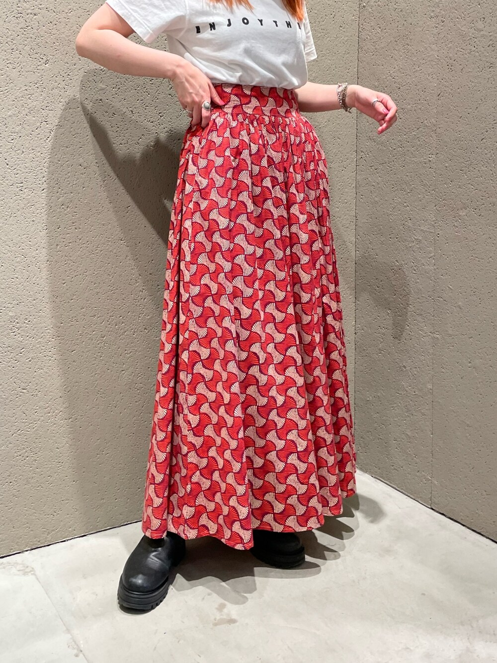 ホワイト系のTシャツ/カットソー、レッド系のスカート、ブラック系のトートバッグを着用したレディースの夏コーディネートの5枚目の写真