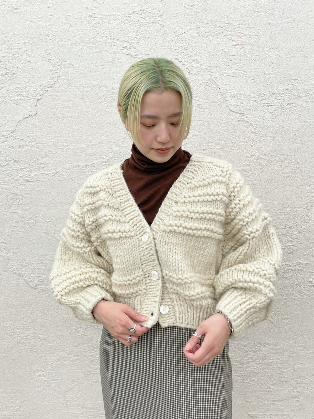 ホワイト系のカーディガン/ボレロ、グリーン系のスカートを着用したレディースの秋コーディネートの3枚目の写真