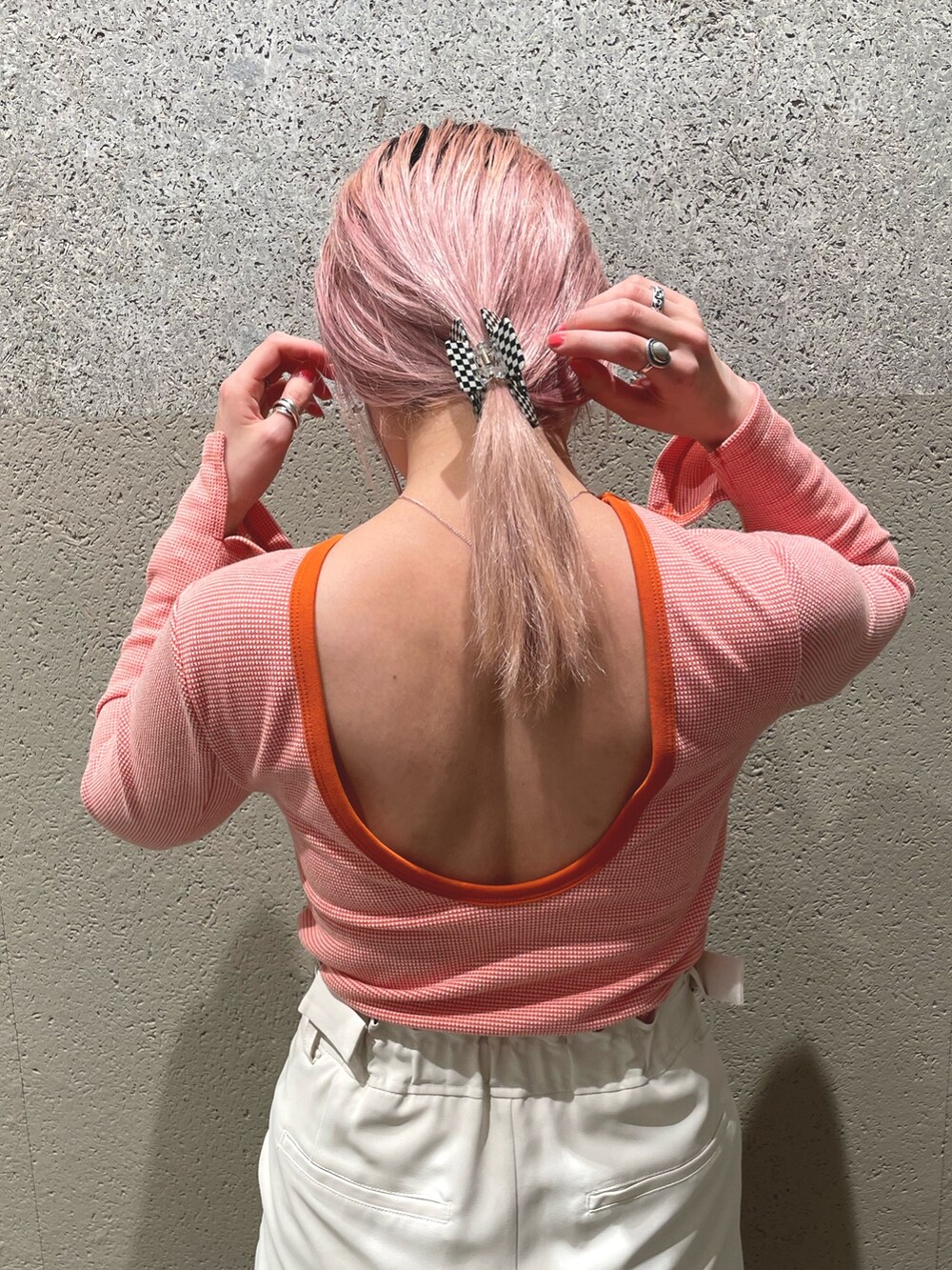 ホワイト系のベスト、オレンジ系のTシャツ/カットソー、ホワイト系のスラックスを着用したレディースの春コーディネートの4枚目の写真