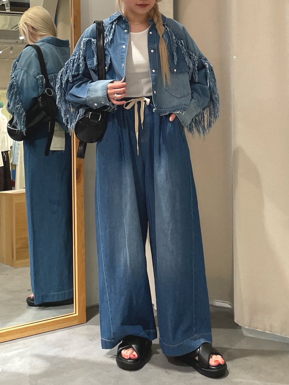 ブルー系のシャツ/ブラウス、ブルー系のデニムパンツ、ブラック系のサンダルを着用したレディースの夏コーディネートの2枚目の写真