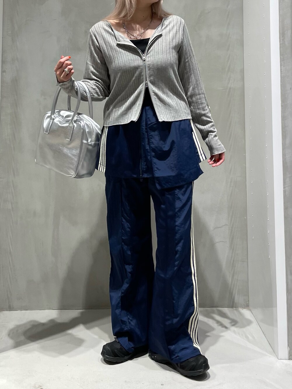 グレー系のカーディガン/ボレロ、ブルー系のスカート、ブルー系のスウェットパンツを着用したレディースの秋コーディネートの2枚目の写真