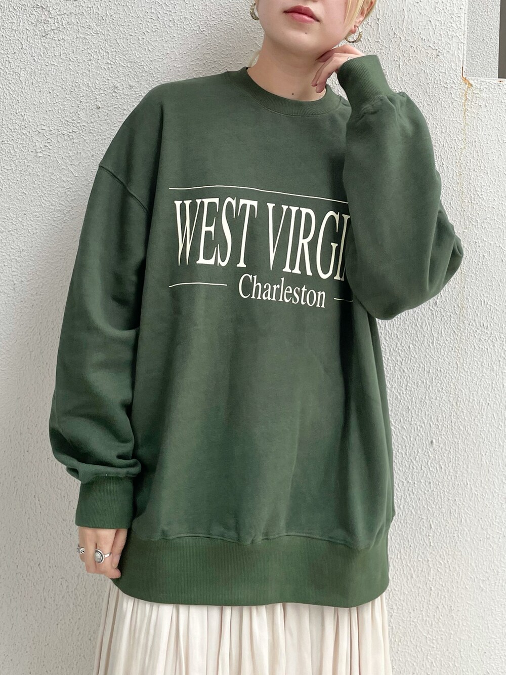 ブラック系のベスト、グリーン系のTシャツ/カットソー、ホワイト系のスカートを着用したレディースの秋コーディネートの4枚目の写真