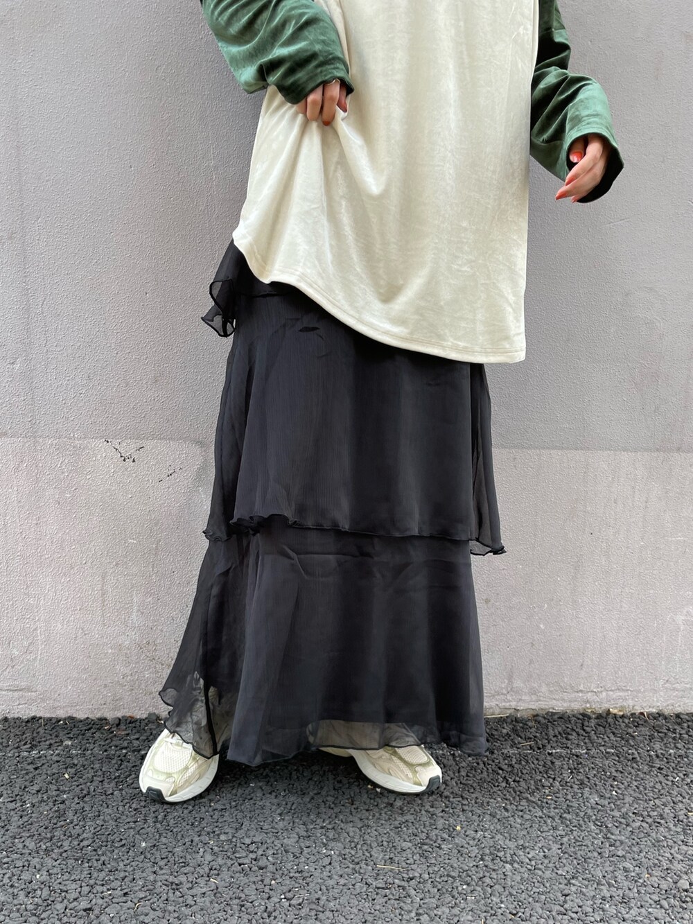 グリーン系のTシャツ/カットソー、イエロー系のトートバッグ、ブラック系のスカートを着用したレディースの秋コーディネートの5枚目の写真