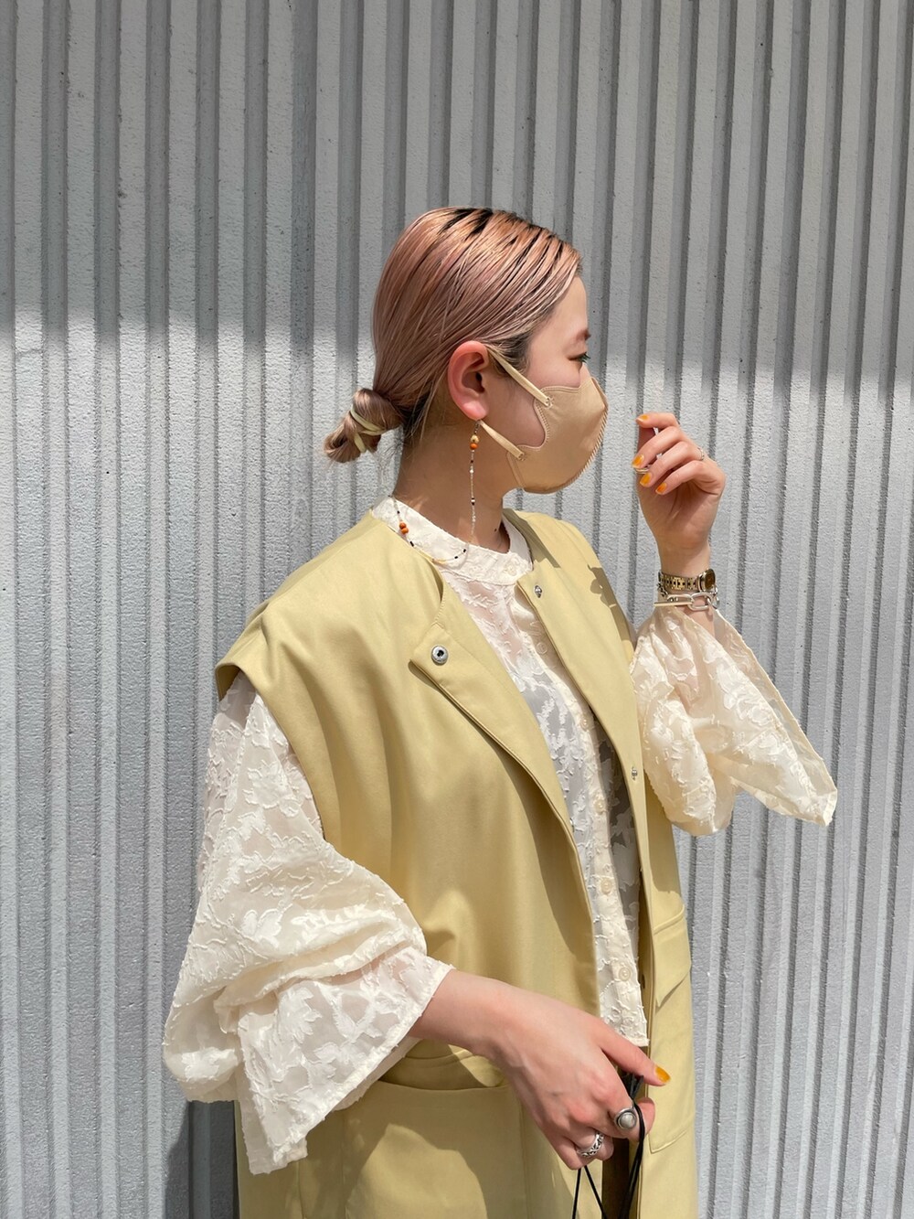 イエロー系のベスト、ホワイト系のシャツ/ブラウス、イエロー系のスラックスを着用したレディースの春コーディネートの4枚目の写真