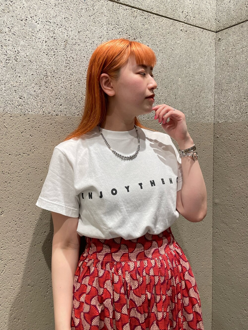 ホワイト系のTシャツ/カットソー、レッド系のスカート、ブラック系のトートバッグを着用したレディースの夏コーディネートの3枚目の写真