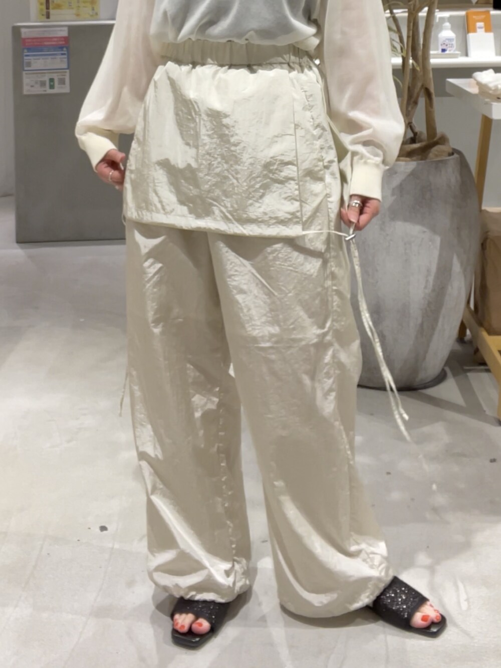 ホワイト系のニット/セーター、ホワイト系のサロペット/オーバーオール、シルバー系のバッグを着用したレディースの春コーディネートの5枚目の写真