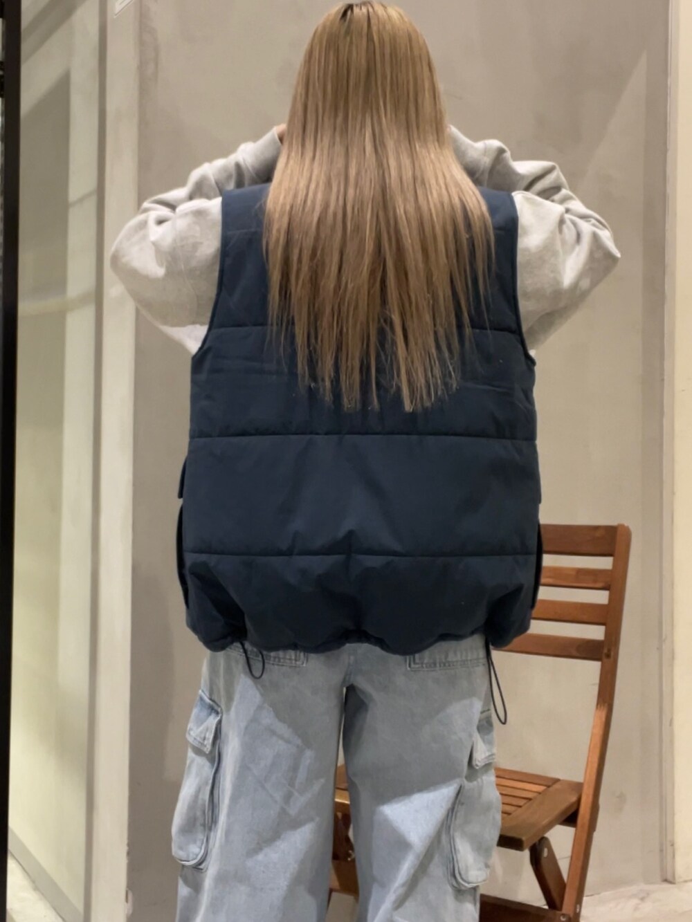 ブルー系のベスト、グレー系のスウェット、ブルー系のカーゴパンツを着用したレディースの冬コーディネートの9枚目の写真