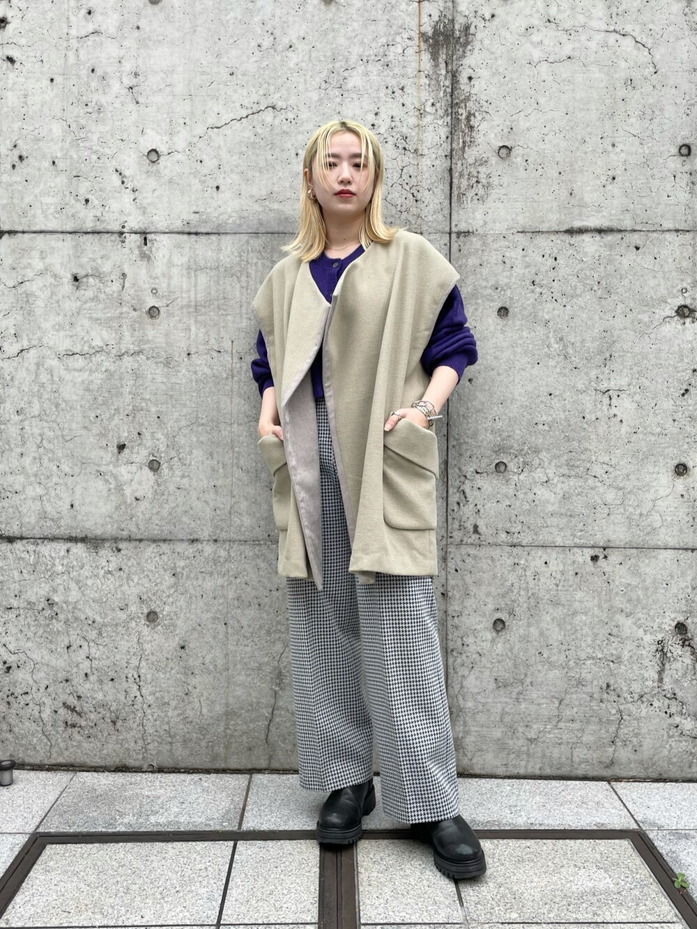 ベージュ系のベスト、パープル系のカーディガン/ボレロ、ブラック系のパンツを着用したレディースの秋コーディネートの2枚目の写真