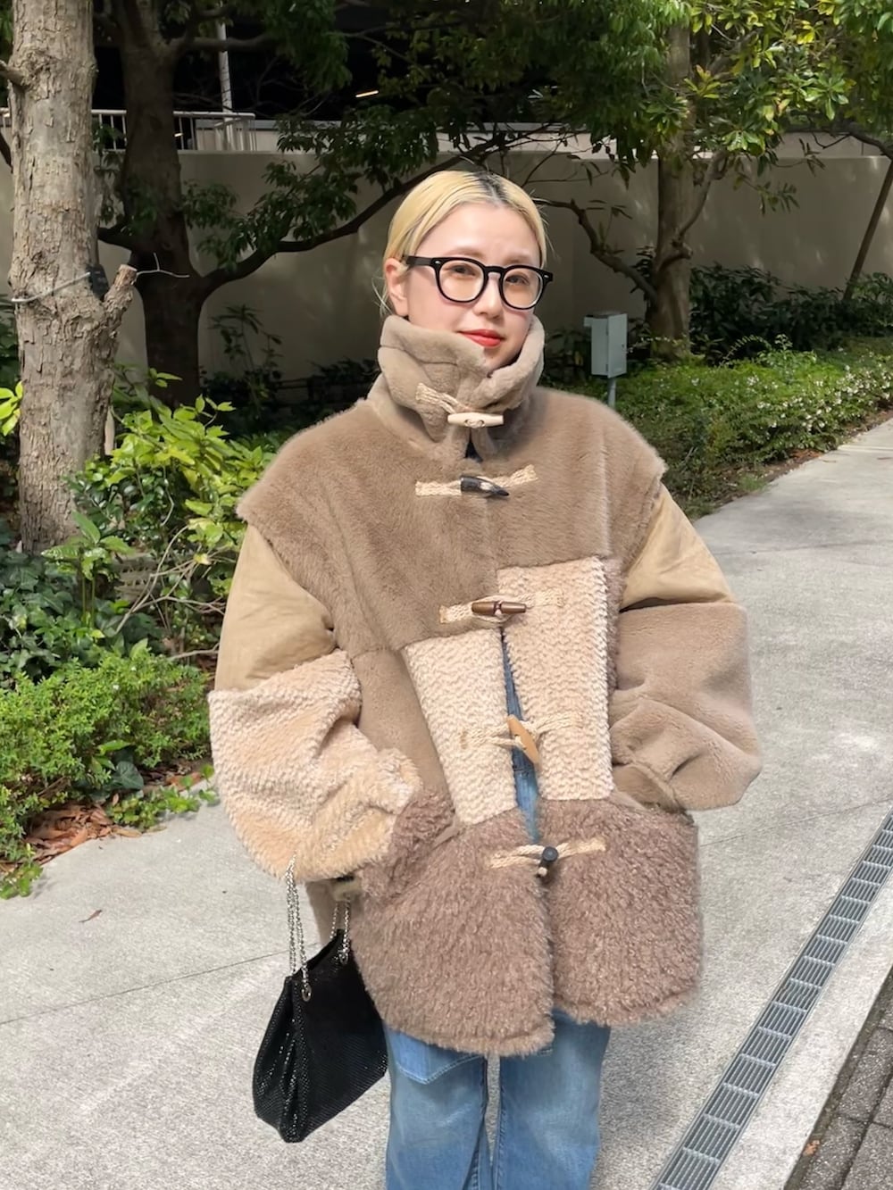 ブラウン系のジャケット/アウター、ブラック系のショルダーバッグ、ブルー系のデニムパンツを着用したレディースの秋コーディネートの6枚目の写真