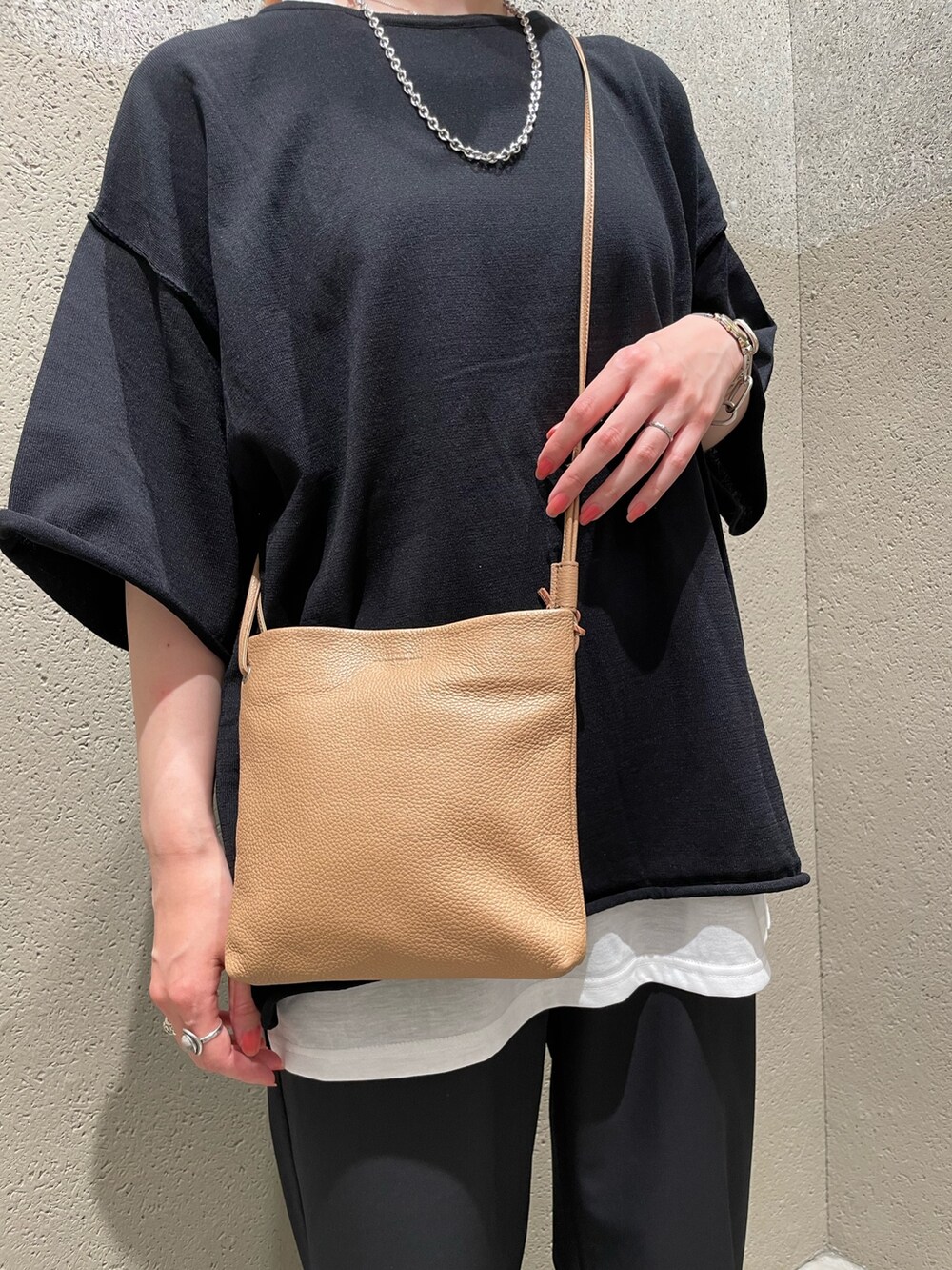 ブラック系のニット/セーター、ブラック系のショルダーバッグ、ブラック系のその他パンツを着用したレディースの夏コーディネートの5枚目の写真