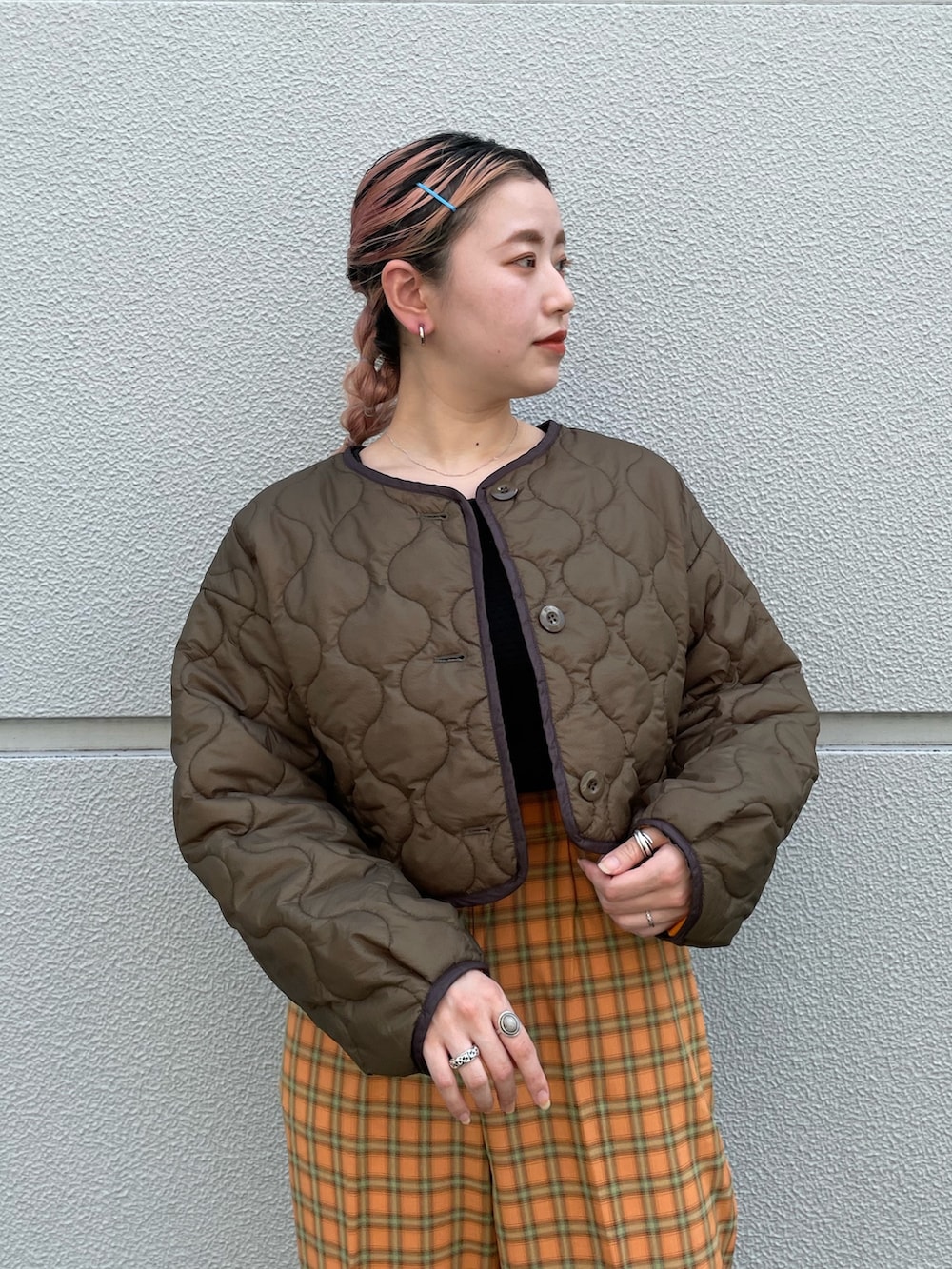 グリーン系のノーカラーコート、オレンジ系のスラックスを着用したレディースの夏コーディネートの5枚目の写真