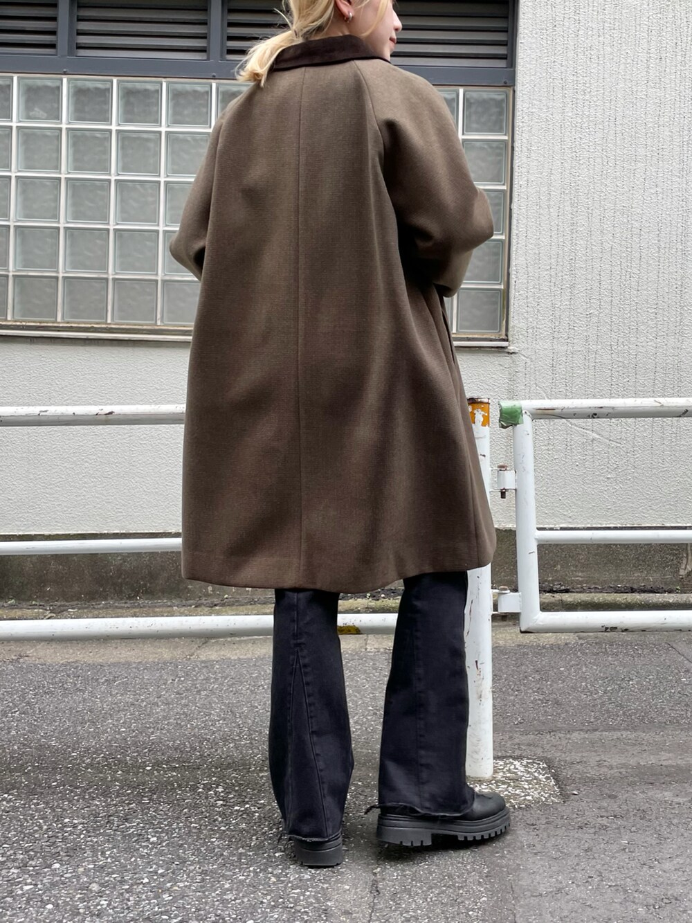 グリーン系のステンカラーコート、ブラウン系のベスト、ブラック系のシャツ/ブラウスを着用したレディースの秋コーディネートの2枚目の写真