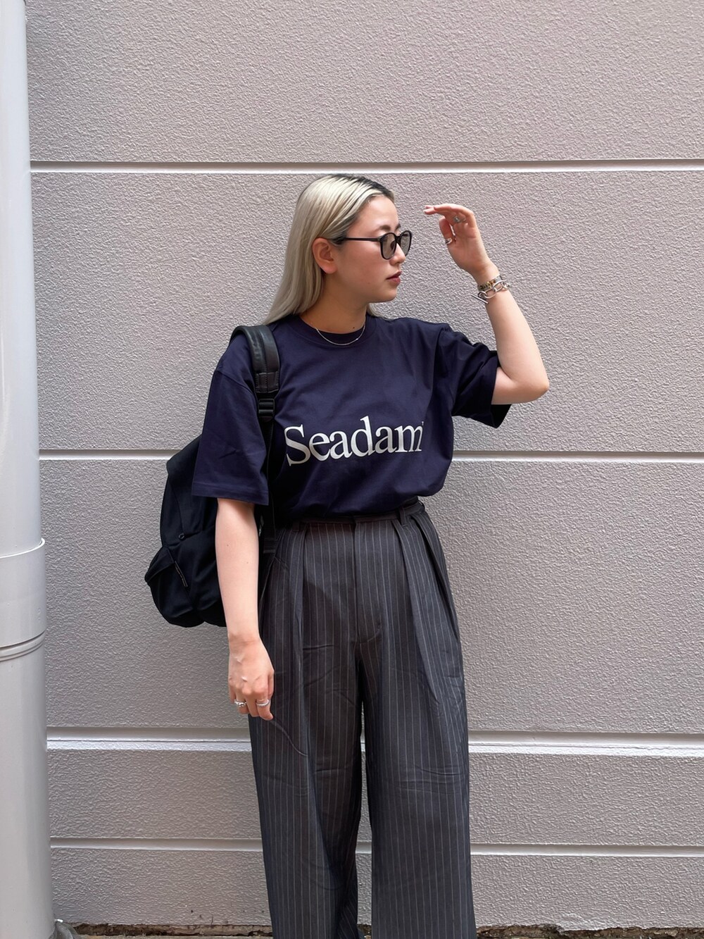 ブルー系のTシャツ/カットソー、グレー系のパンツ、ブラック系のスニーカーを着用したレディースの夏コーディネートの2枚目の写真