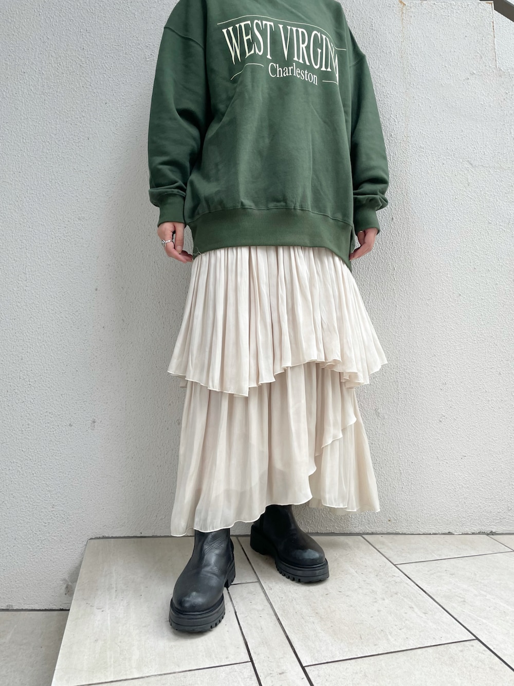 ブラック系のベスト、グリーン系のTシャツ/カットソー、ホワイト系のスカートを着用したレディースの秋コーディネートの5枚目の写真