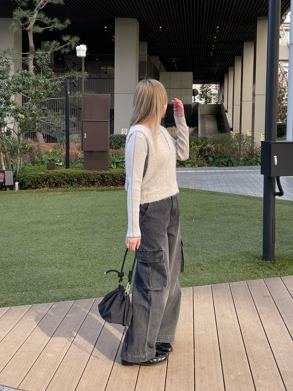 グレー系のベスト、グレー系のニット/セーター、ブラック系のバッグを着用したレディースの冬コーディネートの6枚目の写真