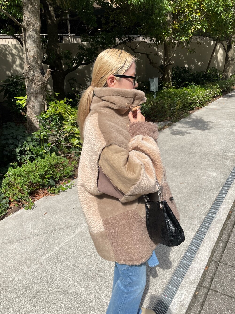 ブラウン系のジャケット/アウター、ブラック系のショルダーバッグ、ブルー系のデニムパンツを着用したレディースの秋コーディネートの7枚目の写真