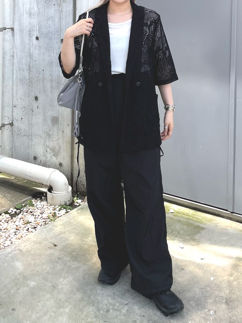 ブラック系のテーラードジャケット、グレー系のバッグ、ブラック系のサロペット/オーバーオールを着用したレディースの夏コーディネートの3枚目の写真
