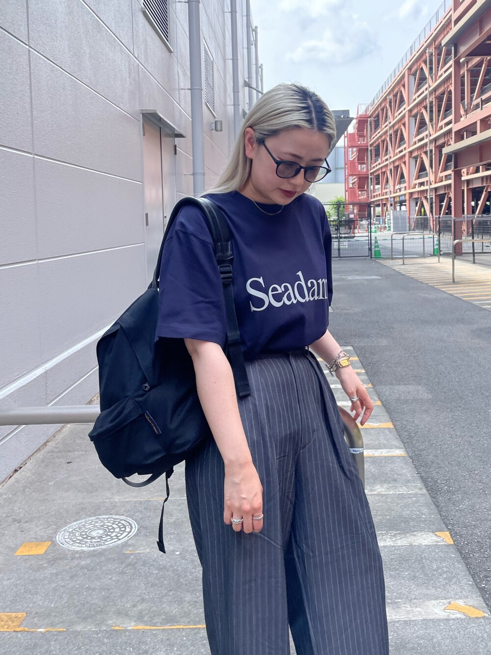 ブルー系のTシャツ/カットソー、グレー系のパンツ、ブラック系のスニーカーを着用したレディースの夏コーディネートの4枚目の写真