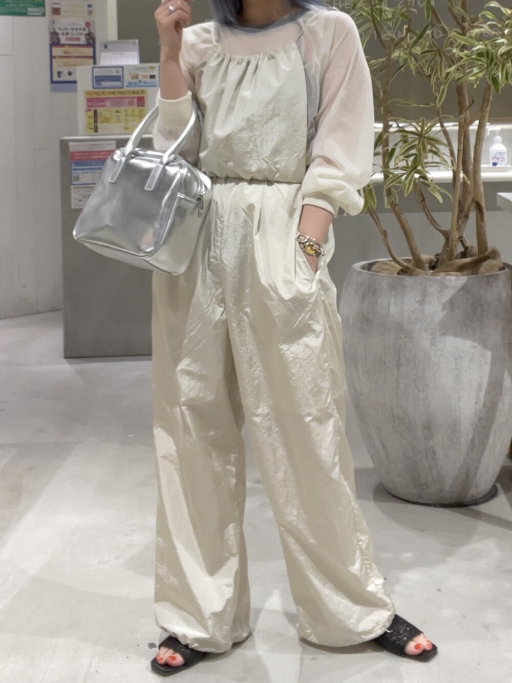 ホワイト系のニット/セーター、ホワイト系のサロペット/オーバーオール、シルバー系のバッグを着用したレディースの春コーディネートの6枚目の写真