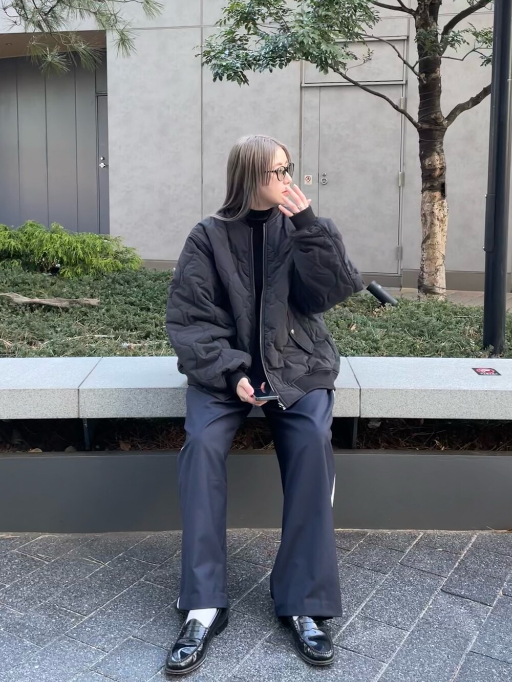 ブラック系のジャケット/アウター、ブラック系のニット/セーター、ブルー系のスラックスを着用したレディースの冬コーディネートの5枚目の写真