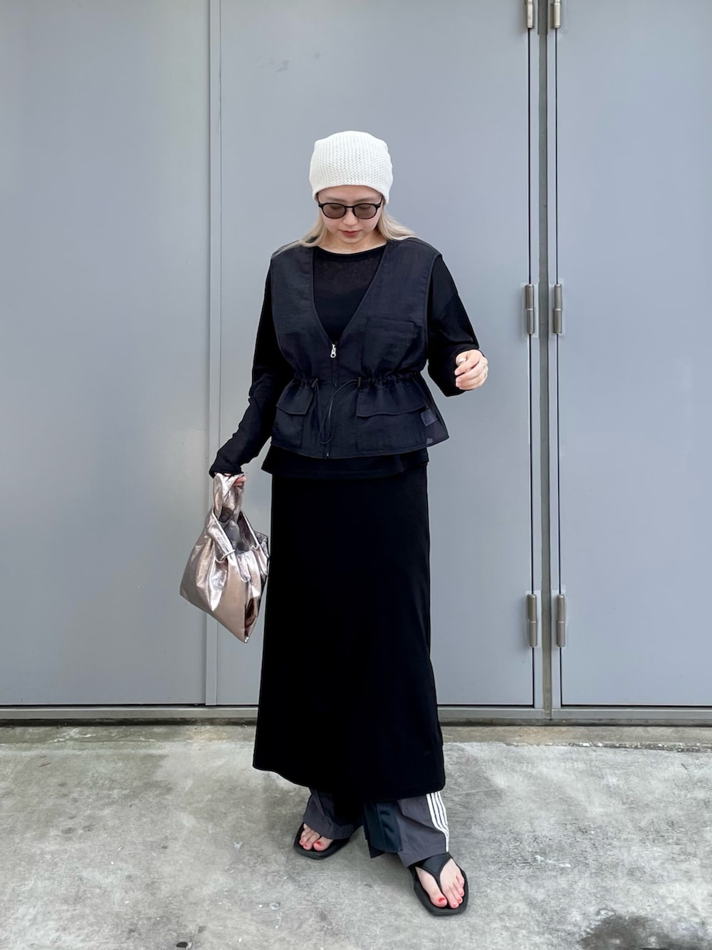 ブラック系のTシャツ/カットソー、ブラック系のベスト、グレー系のスウェットパンツを着用したレディースの夏コーディネートの2枚目の写真