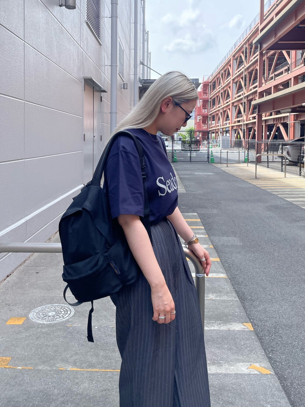 ブルー系のTシャツ/カットソー、グレー系のパンツ、ブラック系のスニーカーを着用したレディースの夏コーディネートの5枚目の写真